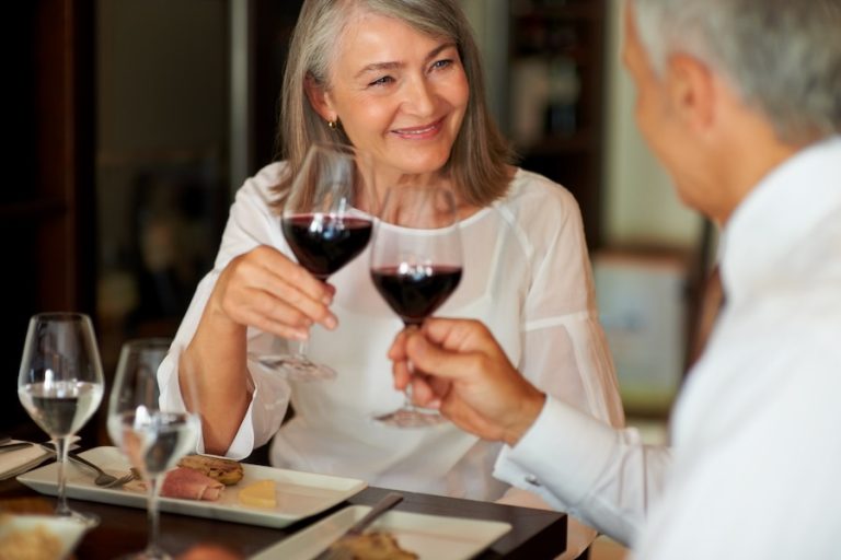 Elderly woman toasting wine with her husband at a smart restaurant